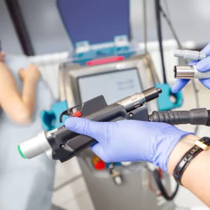 Meta Title: Epilare definitivă cu laser diodă sau laser Alexandrite? Meta Description: Din acest articol vei afla diferențele dintre cele mai populare tipuri de laser pentru epilare definitivă, laser diodă vs. laser Alexandrite. URL: https://doctorskin.ro/epilare-definitiva-laser-dioda-vs-laser-alexandrite Epilarea definitivă: Avantaje și dezavantaje în epilarea cu laser diodă vs. laser Alexandrite În acest articol, vom explora în detaliu tot ce trebuie să știi despre epilarea definitivă și diferențele dintre epilarea cu laser diodă, respectiv laser Alexandrite, pentru a te ajuta să alegi varianta potrivită pentru nevoile tale. În căutarea unei soluții eficiente și de încredere pentru îndepărtarea părului nedorit, din ce în ce mai multe persoane aleg epilarea definitivă cu laser. Această metodă a câștigat popularitate datorită rezultatelor semnificative pe termen lung pe care le oferă. Epilarea definitivă reprezintă o revoluție în ceea ce privește îndepărtarea părului nedorit. Această tehnică avansată utilizează tehnologii laser de vârf pentru a oferi rezultate de lungă durată și netezimea pielii pe termen îndelungat. Prin absorbția selectivă a luminii laserului în foliculii de păr, această procedură inhibă creșterea ulterioară a firelor de păr, oferind o soluție eficientă și convenabilă pentru cei care doresc să scape de rutina epilărilor regulate. Epilarea definitivă s-a impus ca o metodă preferată pentru cei care își doresc o piele catifelată și fără păr, indiferent de zona corpului. Două dintre cele mai utilizate tipuri de lasere pentru epilarea definitivă sunt laser diodă și laser Alexandrite. Dar e timpul să explorăm care sunt diferențele dintre ele și care dintre acestea se potrivește cel mai bine nevoilor tale. Care sunt diferențele cheie dintre laser diodă și laser Alexandrite? Eficiența pe diverse tipuri de piele și păr Laserul diodă se remarcă prin adaptabilitatea sa. Funcționând bine pe o gamă largă de culori de piele, de la cele mai deschise la cele mai închise, laserul diodă oferă rezultate uniforme indiferent de tonul pielii. De asemenea, este adecvat pentru părul de la blond închis până la negru profund. Laserul Alexandrite este mai selectiv în privința tipurilor de piele și păr. De regulă, se descurcă mai bine pe pielea deschisă și părul închis, dar doar dacă părul se regăsește la nivelul superficial al dermului. Este opțiunea potrivită pentru persoanele cu pielea de tip I-II și părul închis. Viteză și precizie ► Laserul diodă este optimizat pentru tratamentele de epilare rapide. Cu impulsuri mai scurte, oferă un grad mare de viteză, ceea ce îl face eficient pe zonele mai mari ale corpului. Astfel, ședința de epilare definitivă poate fi terminată mai repede, fiind ideal pentru zone precum picioarele sau spatele. ►Laserul Alexandrite are avantajul preciziei. Prin emisia de impulsuri mai lente, este preferat pentru tratarea zonelor mai mici sau delicate ale corpului. Acest lucru asigură o experiență mai atentă pentru pacienți, minimizând riscul de arsuri sau iritații. Gradul de confort ► Laserul diodă oferă un nivel redus de disconfort, datorită sistemului său de răcire integrat. Acest lucru asigură o experiență de epilare plăcută pentru pacienți, reducând la minim senzațiile neplăcute din timpul tratamentului. ► Laserul Alexandrite poate fi mai sensibil în anumite cazuri. Deși oferă rezultate excelente, pacienții pot avea nevoie de o toleranță mai mare la disconfort în timpul tratamentului. Laserul diodă: eficiență înaltă și versatilitate remarcabilă Laserul diodă reprezintă o inovație semnificativă în tehnologia de epilare definitivă, dând dovadă de o eficiență și o versatilitate remarcabile în îndepărtarea părului nedorit. Această tehnologie avansată funcționează prin emiterea unei lumini concentrate într-o anumită zonă a spectrului. Această lumină este absorbită de pigmenții din foliculul de păr, care conține melanină. Procesul de absorbție a luminii generează căldură, care este direcționată către folicul. Această căldură distructivă este administrată în mod controlat și previne creșterea ulterioară a firului de păr. Avantaje ale laserului diodă Eficacitate ridicată, indiferent de culoarea pielii Laserul diodă se remarcă prin capacitatea sa de a oferi rezultate remarcabile indiferent de culoarea pielii. De la tonuri deschise la cele mai închise, acesta oferă o eficacitate notabilă în epilarea definitivă. Prin absorbția precisă a luminii de către pigmenții din foliculul de păr, laserul diodă este proiectat pentru a inhiba creșterea ulterioară a firelor de păr. Această adaptabilitate face din laserul diodă o alegere ideală pentru o varietate de pacienți, indiferent de fototipul pielii lor. Rapiditate remarcabilă Laserul diodă se distinge prin capacitatea sa de a trata suprafețe mari de piele într-un timp scurt. Acest lucru se datorează impulsurilor mai lungi emise de echipamentul laser, care permit acoperirea unei suprafețe mari de pe corp într-o singură ședință de epilare. Rezultatul? Ședințe de tratament mai rapide și mai eficiente. Această caracteristică nu numai că economisește timpul pacientului, dar contribuie și la eficiența generală a procedurii de epilare progresiv definitivă. Nivel scăzut de disconfort Un alt avantaj notabil al laserului diodă este gradul redus de disconfort resimțit de pacienți în timpul ședinței de epilare. Acest lucru se datorează sistemului de răcire integrat în aparat, care funcționează eficient pentru a proteja pielea și a reduce senzația neplăcută de disconfort asociată cu procedura. Pacienții spun că disconfortul este mult mai mic în comparație cu tehnologii similare precum IPL sau SPL, ceea ce face din laserul diodă o opțiune confortabilă pentru cei care caută ca epilarea definitivă să nu fie o experiență traumatizantă. Prin aceste avantaje distincte, laserul diodă s-a impus ca o alegere preferată în rândul tehnologiilor de epilare definitivă. Eficiența sa notabilă pe o gamă variată de tipuri de piele, rapiditatea și eficiența tratamentelor, împreună cu nivelul scăzut de disconfort, contribuie la popularitatea sa crescândă în rândul pacienților. Dezavantaje ale laserului diodă Eficiență limitată pe părul blond, roșcat sau grizonat Laserul cu diodă se dovedește mai puțin eficient în îndepărtarea firelor de păr blond sau grizonat, deoarece acestea conțin mai puțină melanină. Potențiale riscuri de hiperpigmentare pe pielea mai închisă la culoare În cazul pacienților cu pielea mai închisă la culoare, există un risc de hiperpigmentare, deoarece laserul cu diodă poate provoca absorbția excesivă a luminii, determinând pigmentarea excesivă a pielii. Necesită ședințe suplimentare pentru rezultate optime Pentru a obține rezultatele dorite, pot fi necesare mai multe ședințe de tratament în comparație cu alte tipuri de lasere. Laserul Alexandrite: eficiență și viteză în epilarea definitivă Laserul Alexandrite este un dispozitiv avansat care utilizează o lungime de undă specifică, bine calibrată, pentru a viza pigmenții melanici din foliculul de păr. Această lumină este absorbită de melanină, generând căldură. Căldura produsă este direcționată către folicul, iar acest proces controlat distruge capacitatea foliculului de a produce păr nou. Avantaje ale laserului Alexandrite Tratament rapid pentru zonele mari ale corpului Laserul Alexandrite se remarcă prin capacitatea sa de a emite impulsuri rapide, ceea ce îl face ideal pentru tratarea zonelor extinse ale corpului. Această caracteristică permite finalizarea ședințelor de epilare într-un timp mai scurt, făcându-l o alegere excelentă pentru zone precum picioarele sau spatele. Eficiență remarcabilă pe pielea deschisă cu păr închis Acest laser se evidențiază prin eficacitatea sa remarcabilă pe pielea deschisă asociată cu părul închis. Persoanele cu această combinație de caracteristici vor avea rezultate excelente, datorită capacității sale de a viza și distruge firele de păr în mod eficient. Studii clinice demonstrează eficiența laserului Alexandrite Studiile clinice au evidențiat eficiența laserului Alexandrite în îndepărtarea părului pe termen lung. Acesta a demonstrat rezultate remarcabile în reducerea creșterii părului, consolidându-și astfel reputația de opțiune eficientă în epilarea definitivă. Prin viteză și precizie, laserul Alexandrite se impune ca alegerea preferată pentru tratarea suprafețelor extinse de pe corp. Este deosebit de eficient pe pielea deschisă cu păr închis, furnizând rezultate excelente, așa cum au arătat și studiile clinice. Dezavantaje ale laserului Alexandrite Sensibilitate la pielea închisă cu păr deschis Laserul Alexandrite se dovedește mai puțin eficient pe pielea mai închisă cu fire de păr mai deschise. Acest lucru se datorează dificultății de absorbție a luminii de către firele de păr cu mai puțină melanină. Potențiale riscuri de hipopigmentare În cazul unei absorbții excesive de lumină, există risc de hipopigmentare, care se traduce prin decolorarea temporară a pielii. Acest risc este mai crescut la pacienții cu pielea mai deschisă. Tratament prelungit Din cauza capacității sale de a emite impulsuri mai rapide, ședințele de epilare cu laser Alexandrite pot dura mai mult. Potențial disconfort mai mare la pacienții sensibili Pacienții cu un grad mai mare de sensibilitate pot resimți mai puternic disconfortul în timpul ședinței de epilare cu laserul Alexandrite, deoarece acesta funcționează cu impulsuri mai rapide. Atât laserul diodă cât și laserul Alexandrite sunt opțiuni excelente pentru epilarea definitivă. Alegerea depinde de necesitățile și dorințele tale individuale, iar un specialist experimentat te va ghida spre cea mai bună decizie. Investiția în această procedură poate aduce rezultate remarcabile pe termen lung, sporind astfel nu doar confortul personal dar și încrederea în sine. Descoperă avantajele epilării definitive cu Deka Motus AX Dacă ești în căutarea celei mai performante soluții de epilare definitivă, Deka Motus AX este alegerea perfectă. Acest laser Alexandrite de ultimă generație a fost conceput pentru a oferi rezultate remarcabile, fără compromisuri și, pe lângă costul redus, prezintă o serie de avantaje tehnice notabile. Cum funcționează? Prin epilarea cu Motus AX ai acces la o soluție avansată și completă pentru îndepărtarea părului nedorit de pe corp. Este un sistem laser compact care integrează Alexandrite 755 nm, oferind un echilibru perfect între eficacitate, siguranță și confort. Sistemul integrat în laser permite răcirea pielii imediat după emisia luminii, reducând semnificativ senzația de disconfort în timpul procedurii și eventualele neplăceri ulterioare. Fiecare impuls emis generează o senzație asemenea unui ușor șoc, similar cu senzația de atingere a pielii cu o bandă elastică. În acest sens, este esențial ca tehnicianul să regleze intensitatea impulsului în funcție de particularitățile fiecărui tip de piele. De ce ar trebui să optezi pentru epilarea cu laserul Alexandrite de la Deka? Performanță excepțională Deka Motus AX utilizează tehnologia Alexandrite, cunoscută pentru eficacitatea sa în reducerea părului. După doar câteva ședințe, părul nedorit poate fi redus cu până la 90%. Tehnologie Moveo pentru eficiență maximă Datorită tehnologiei Moveo, laserul Deka Motus AX nu suferă pierderi de energie în timpul ședinței de tratament. Acest lucru se traduce prin rezultate superioare și sesiuni mai rapide. Potrivit pentru orice tip de păr și piele Deka Motus AX este eficient indiferent dacă ai păr fin sau gros. Tehnologia sa avansată abordează fiecare fir de păr în mod precis și eficace. De asemenea, laserul a fost proiectat pentru a fi sigur pe orice tip de piele, inclusiv pe cea bronzată, fără risc de arsuri sau decolorare a pielii, oferindu-ți încredere totală în procedură. Confort maxim cu sistemul de răcire integrat Procedura de epilare definitivă cu Deka Motus AX este una confortabilă, datorită sistemului de răcire integrat în aparat. Acesta asigură o experiență plăcută, cu zero durere. Rezultate rapide și permanente Cu Deka Motus AX, te poți bucura de o piele netedă și fină tot timpul anului. Rezultatele sunt vizibile rapid și persistă pe termen lung. Standard de aur în epilarea definitivă cu laser Deka Motus AX este cunoscut ca fiind standardul de aur în epilarea definitivă, fiind singurul laser Alexandrite din lume cu tehnologia Moveo, cu alte cuvinte singurul Alexandrite la care poți face și vara ședințele de epilare. Alegând acest dispozitiv, alegi calitatea și siguranța pentru procedura de epilare definitivă. În concluzie, alegerea între laserul diodă și laserul Alexandrite depinde de fototipul tău de piele, de culoarea firului de păr, de zona tratată și de timpul pe care îl ai la dispoziție. Ambele lasere oferă rezultate excelente, însă decizia finală depinde de bugetul și de preferințele tale personale. Iar dacă încă nu ești sigur/ă că Motus AX este soluția cea mai potrivită pentru tine, îți oferim o ședință de test GRATUITĂ pentru a te convinge singur/ă de eficacitatea acestui sistem laser revoluționar! Programează-te acum la 031 005.10.15 sau pe mail, la: contact@skinmedspa.ro!